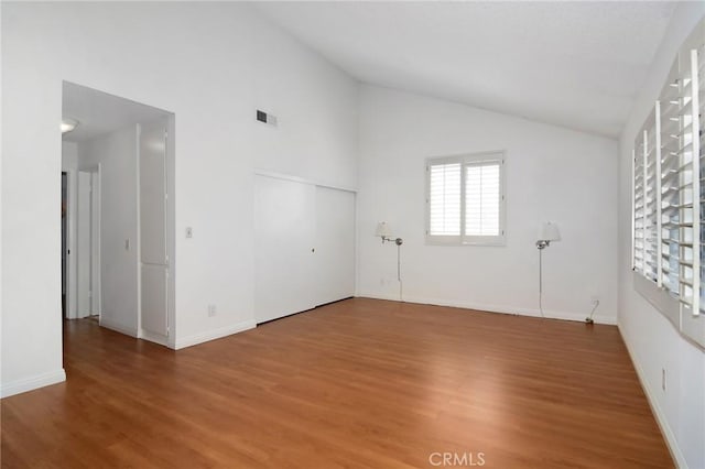 unfurnished room with high vaulted ceiling and hardwood / wood-style flooring