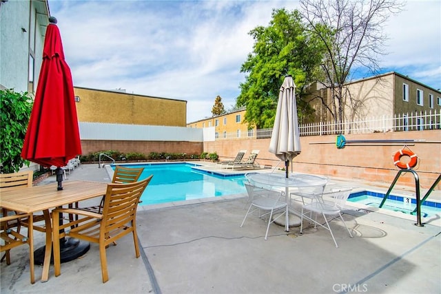 view of pool featuring a patio area and an in ground hot tub