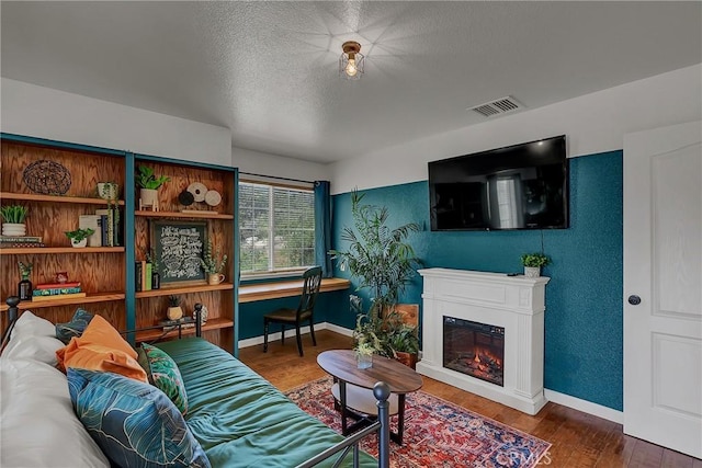 living room with a textured ceiling and dark hardwood / wood-style floors