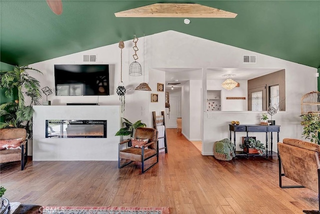 living room with high vaulted ceiling, hardwood / wood-style floors, and beamed ceiling