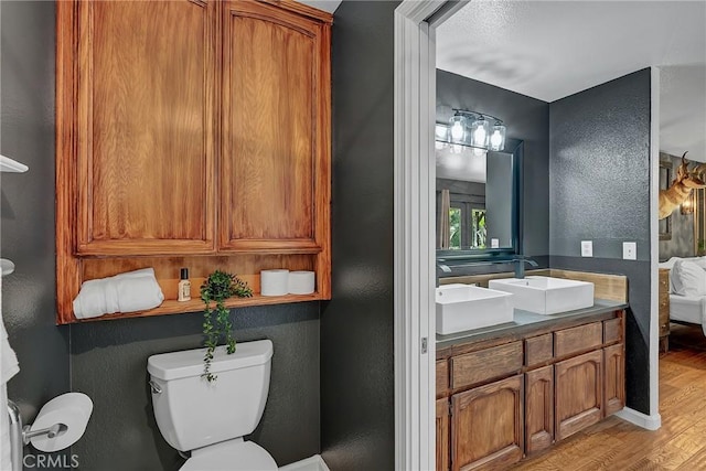 bathroom featuring toilet, hardwood / wood-style flooring, and vanity