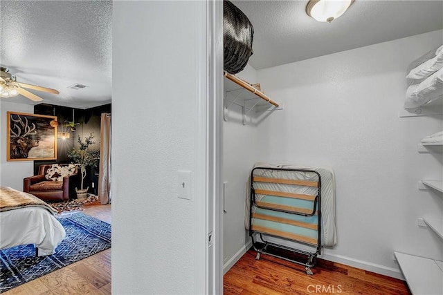 walk in closet featuring hardwood / wood-style flooring and ceiling fan