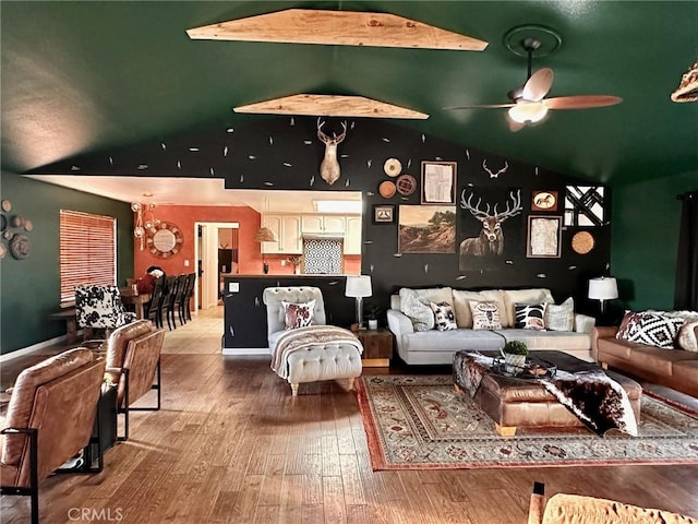 living room featuring ceiling fan, hardwood / wood-style flooring, and lofted ceiling with beams