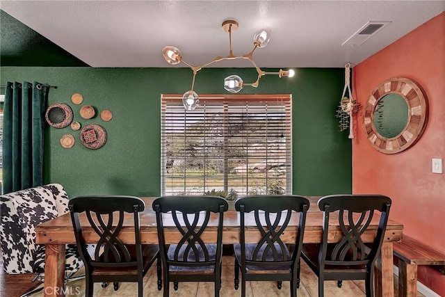 dining space featuring light hardwood / wood-style floors and a textured ceiling