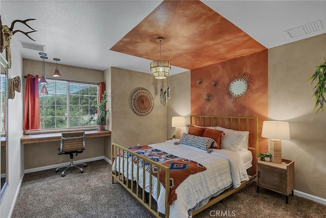 bedroom with dark colored carpet and built in desk