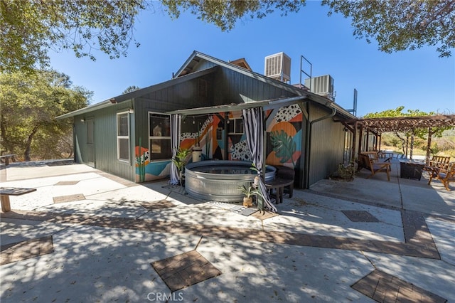 view of front facade featuring cooling unit, a pergola, and a patio