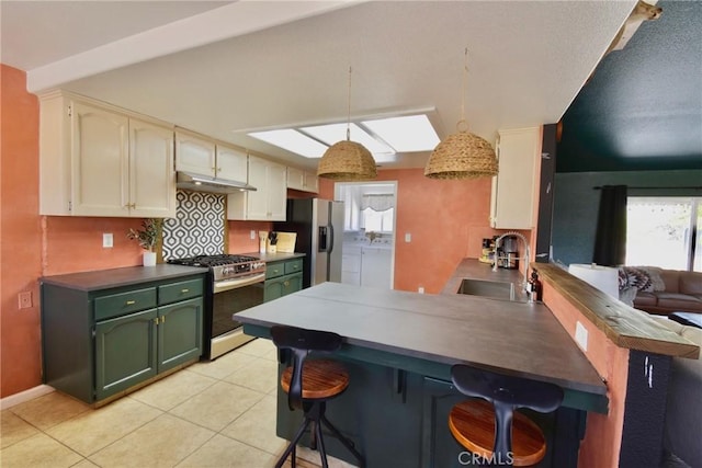 kitchen with kitchen peninsula, stainless steel appliances, independent washer and dryer, hanging light fixtures, and sink