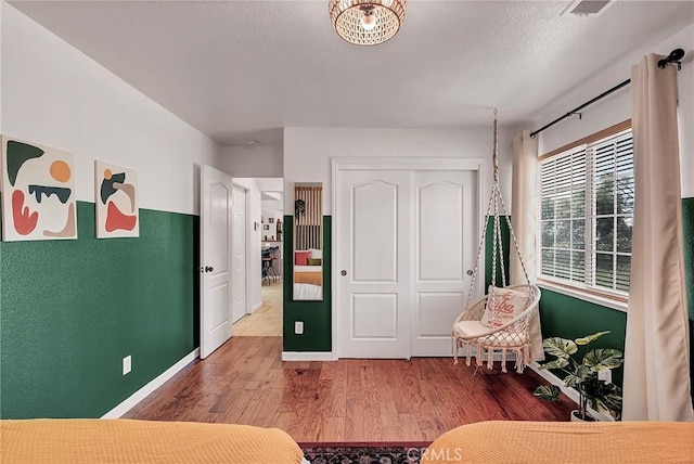 bedroom with a closet, a textured ceiling, and hardwood / wood-style flooring