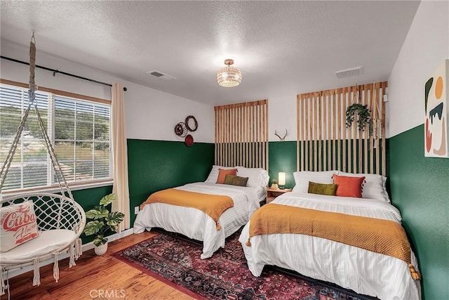 bedroom with a textured ceiling and hardwood / wood-style floors