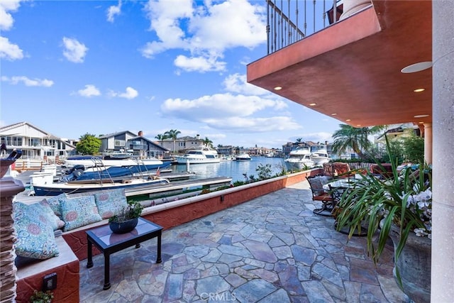 view of patio with a water view and a dock