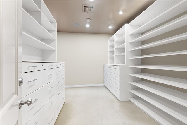 walk in closet featuring light colored carpet