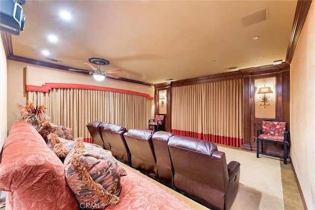 carpeted cinema room with ceiling fan and crown molding