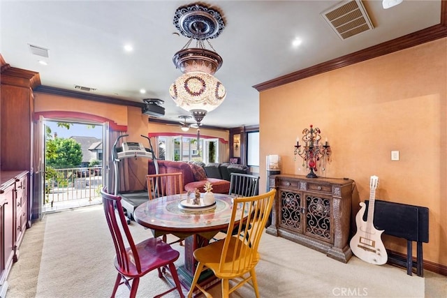 carpeted dining area featuring ceiling fan and crown molding