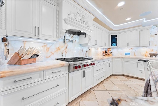 kitchen with tasteful backsplash, white cabinetry, light tile patterned floors, and stainless steel gas cooktop