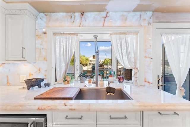 kitchen featuring tasteful backsplash and white cabinetry