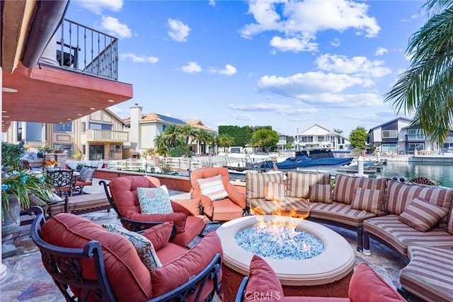 view of patio featuring a water view and an outdoor living space with a fire pit