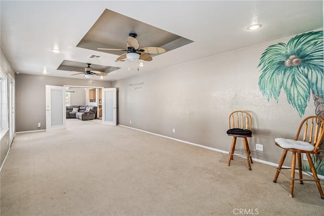 interior space featuring a raised ceiling and ceiling fan