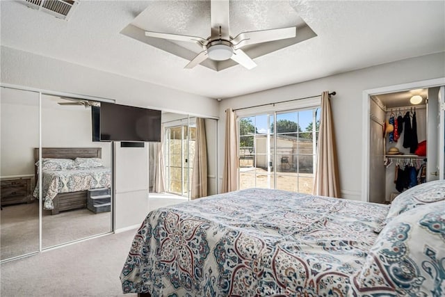 bedroom featuring ceiling fan, light colored carpet, and a textured ceiling