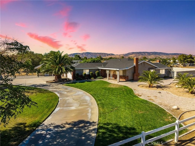 ranch-style house featuring a mountain view and a yard