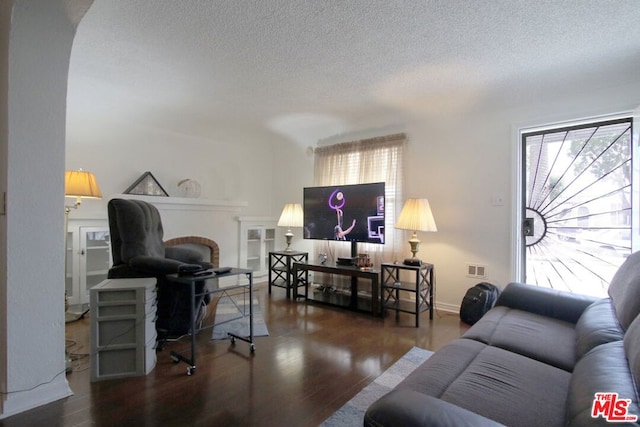 living room featuring a textured ceiling and dark hardwood / wood-style floors