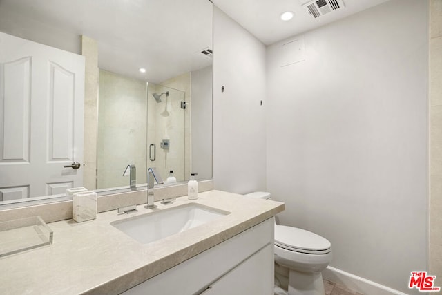 bathroom featuring a shower with shower door, vanity, and toilet