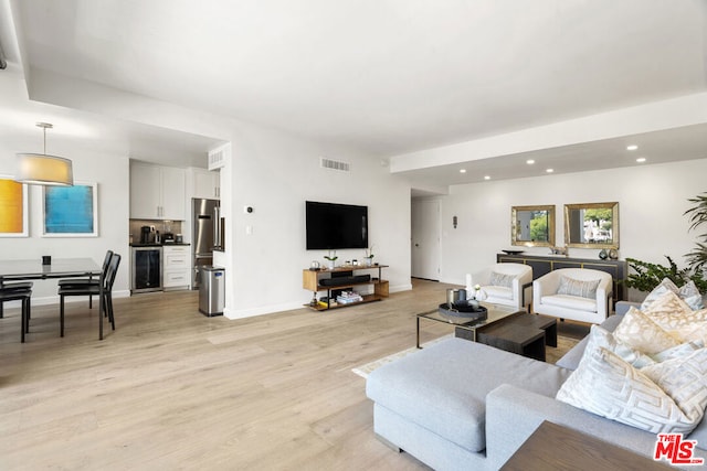 living room featuring beverage cooler and light hardwood / wood-style flooring