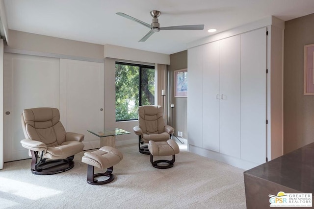 living area featuring ceiling fan and carpet