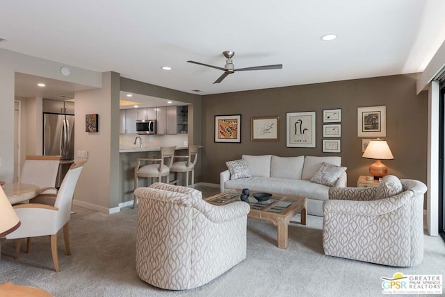 carpeted living room with ceiling fan