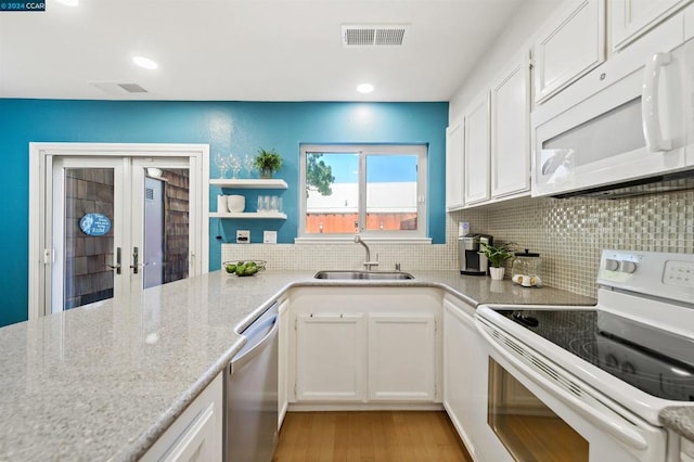 kitchen with white cabinets, white appliances, light hardwood / wood-style flooring, french doors, and sink