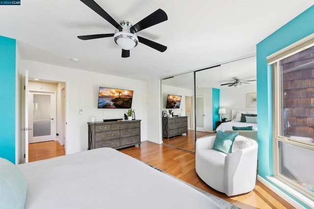 bedroom with ceiling fan, hardwood / wood-style flooring, and a closet