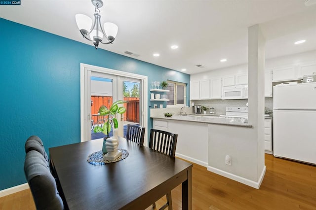 dining room featuring hardwood / wood-style floors, a chandelier, and sink