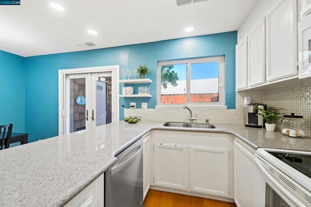 kitchen featuring white cabinets, light hardwood / wood-style flooring, french doors, stainless steel dishwasher, and sink