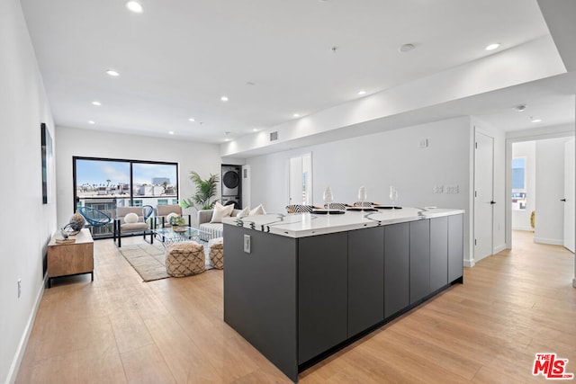 kitchen featuring light wood-type flooring and a large island with sink