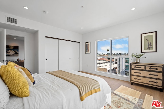 bedroom featuring light wood-type flooring and a closet