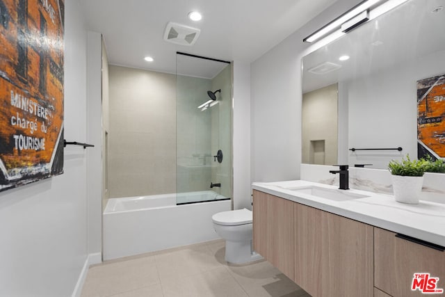 full bathroom featuring tile patterned floors, shower / bath combination with glass door, vanity, and toilet