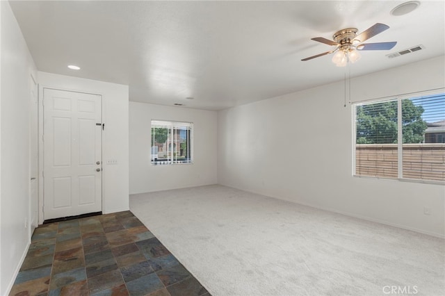 carpeted empty room featuring ceiling fan