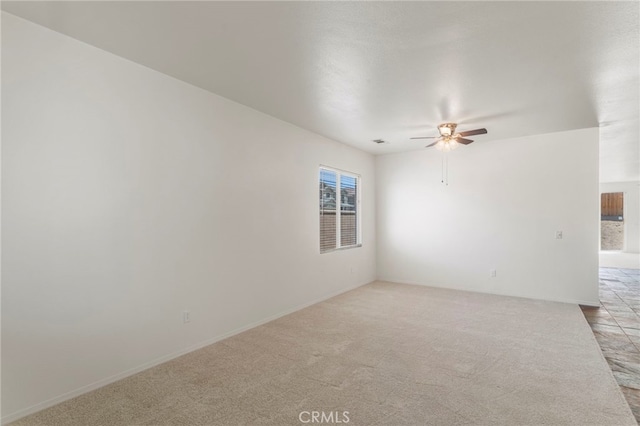 carpeted spare room featuring ceiling fan