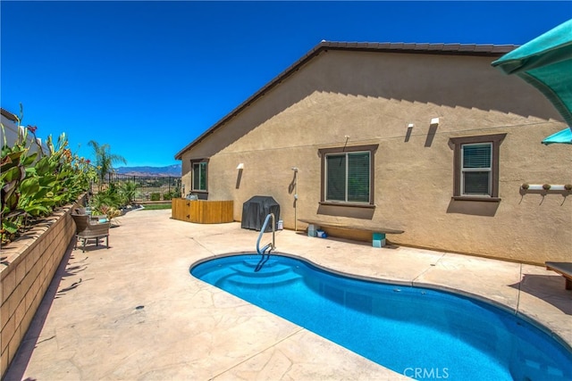 back of house with a mountain view, a patio, and a fenced in pool