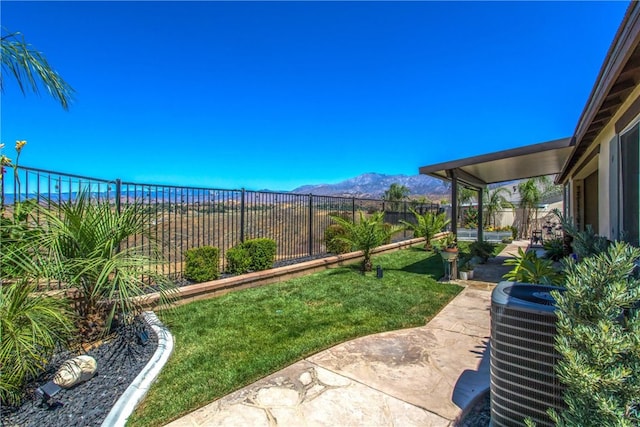 view of yard featuring a patio area, central AC, and a mountain view