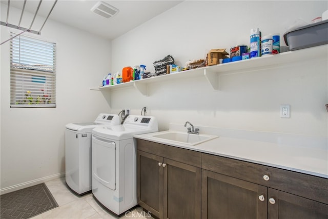 laundry room with cabinets, sink, separate washer and dryer, and light tile patterned floors