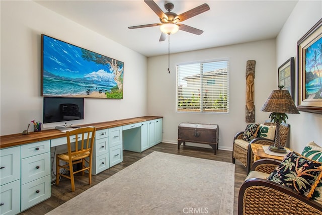 office area with built in desk, ceiling fan, and dark hardwood / wood-style floors