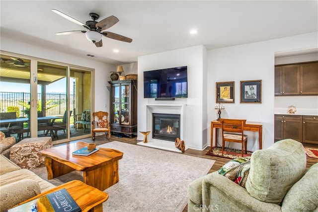 living room featuring wood-type flooring and ceiling fan