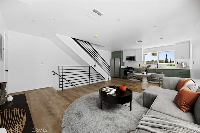 living room featuring hardwood / wood-style floors and sink