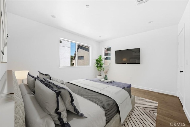 bedroom with dark hardwood / wood-style flooring