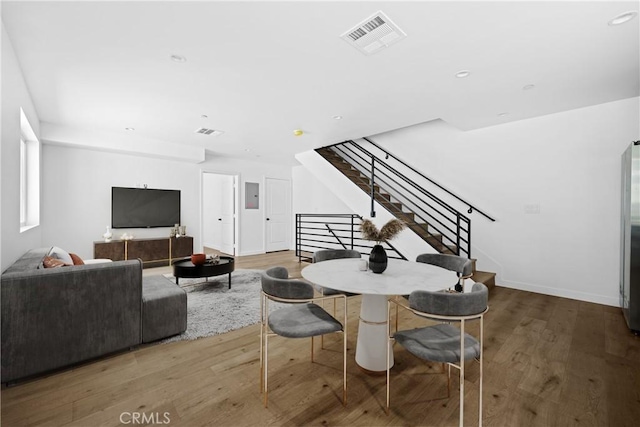 dining space featuring electric panel and hardwood / wood-style flooring