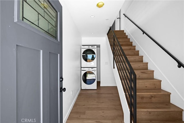 stairway featuring hardwood / wood-style flooring and stacked washer / drying machine