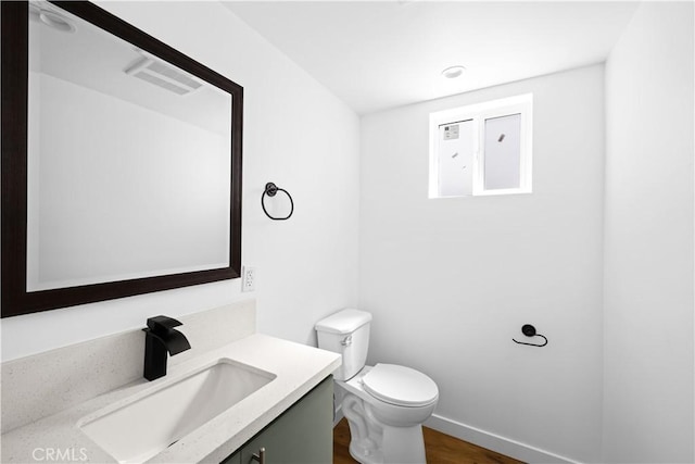 bathroom with vanity, wood-type flooring, and toilet