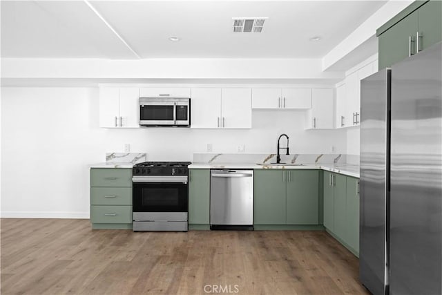 kitchen featuring white cabinetry, green cabinetry, and appliances with stainless steel finishes