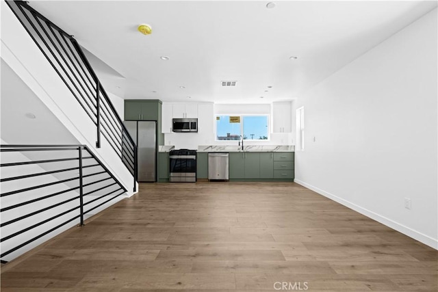 unfurnished living room featuring sink and light wood-type flooring