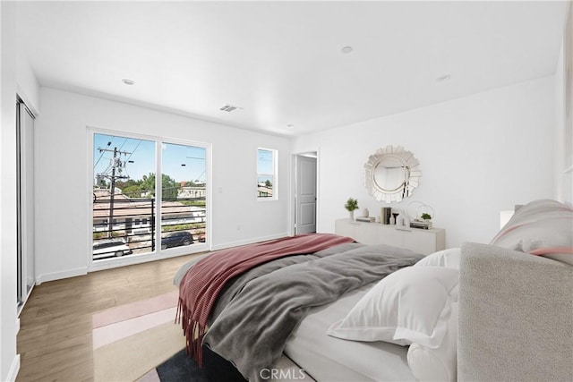 bedroom with wood-type flooring and access to outside